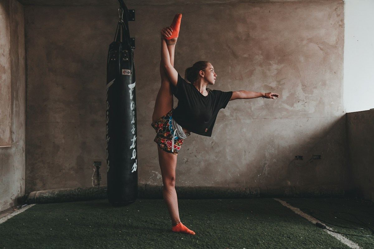 Atleta in equilibrio su una gamba accanto al sacco