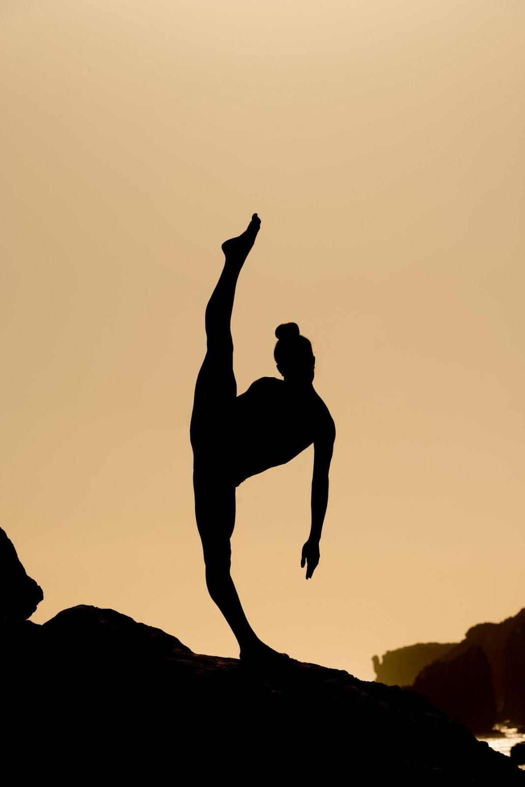 Silhouette di atleta in equilibrio al tramonto
