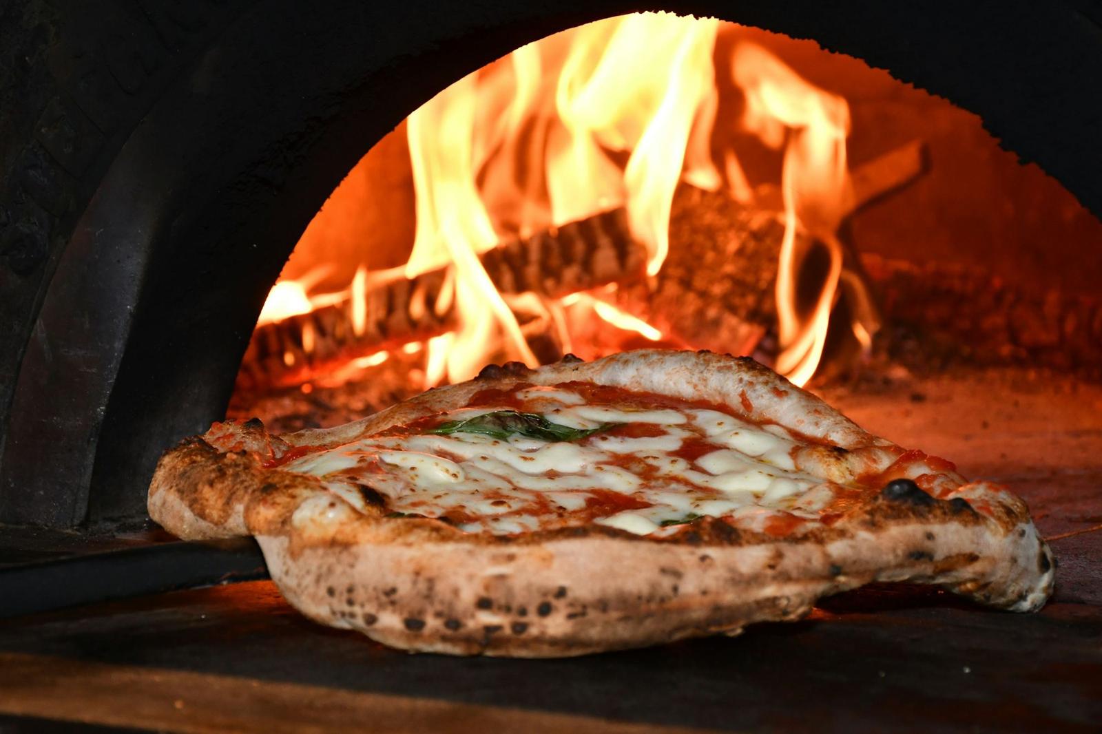 Pizza nel forno a legna